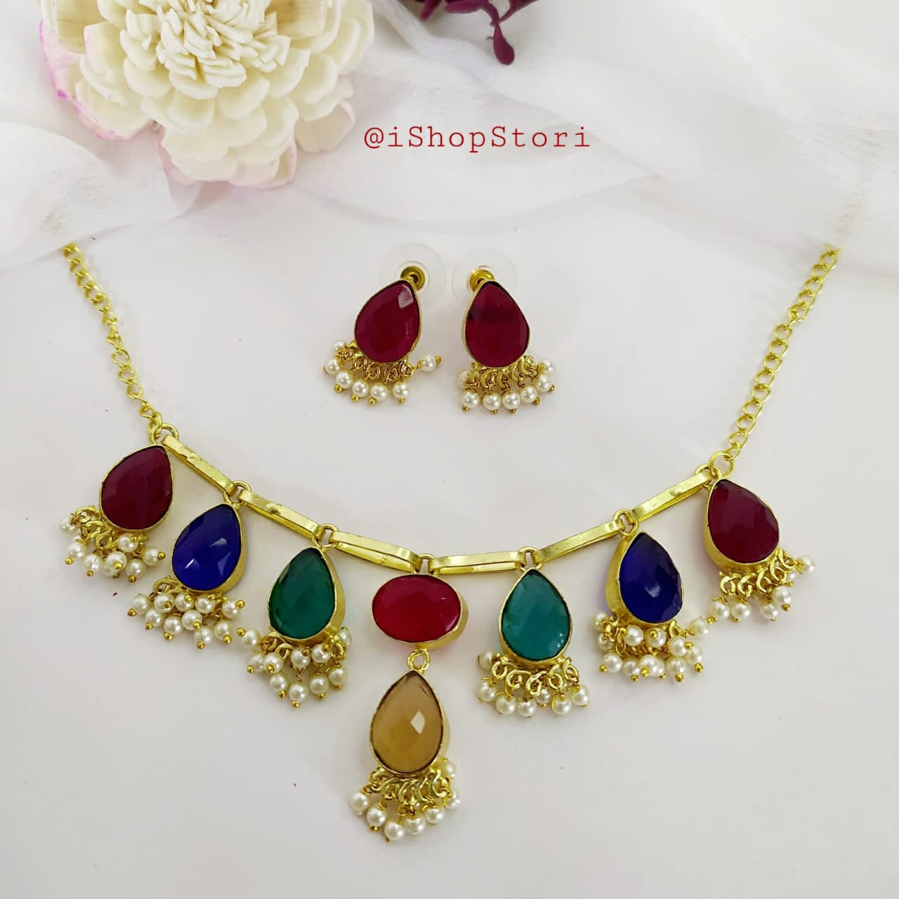 Multicolor pearl necklace with exquisite stone detailing and red earrings front view.