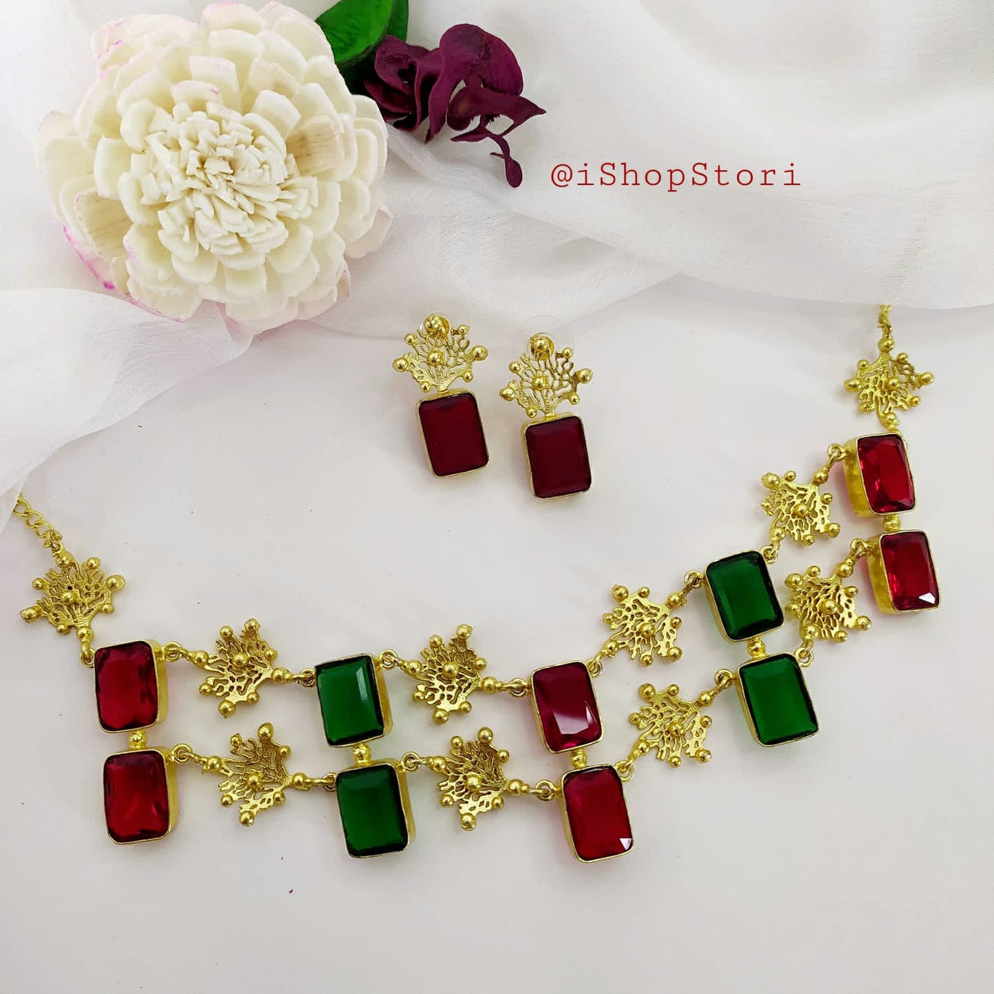 Glossy white stone necklace with a double-layer design and red earrings.
