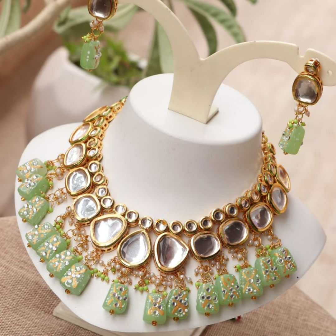 Mint green kundan necklace set with intricate detailing.