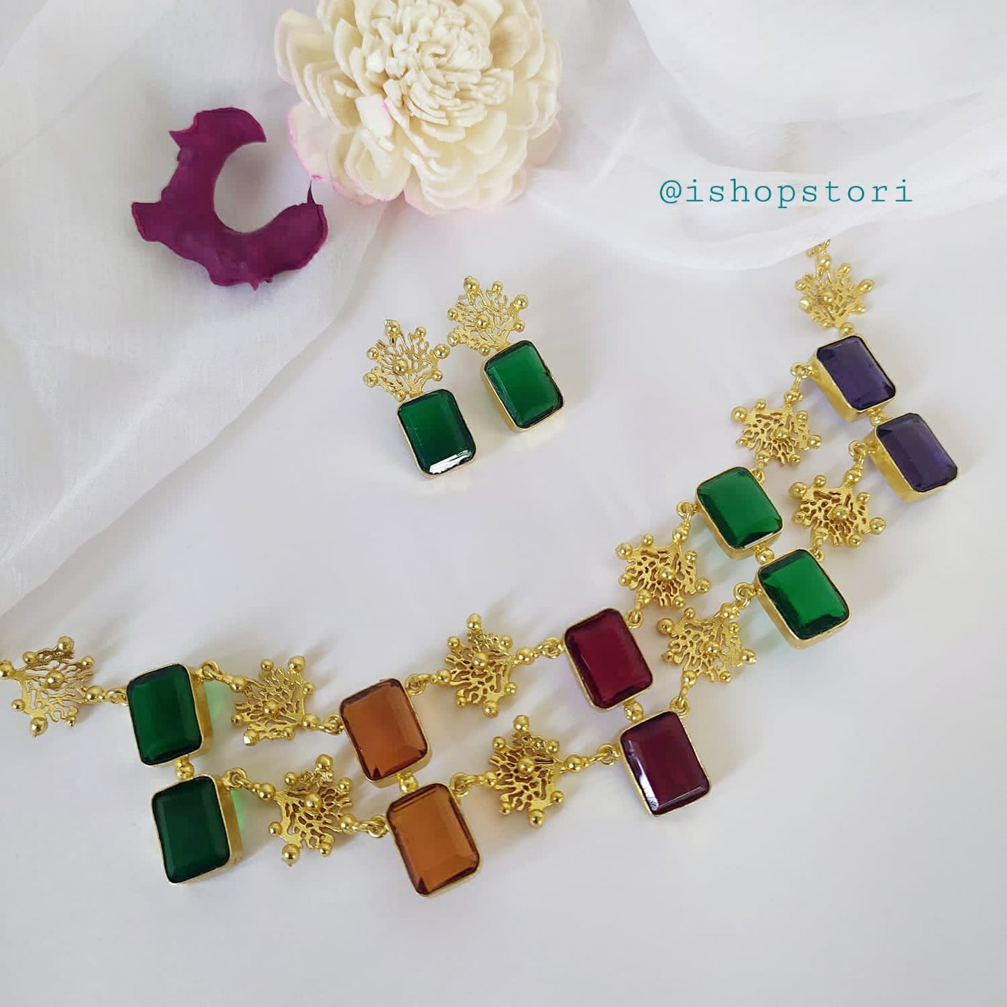 Glossy white stone necklace with a double-layer design and dark green earrings.