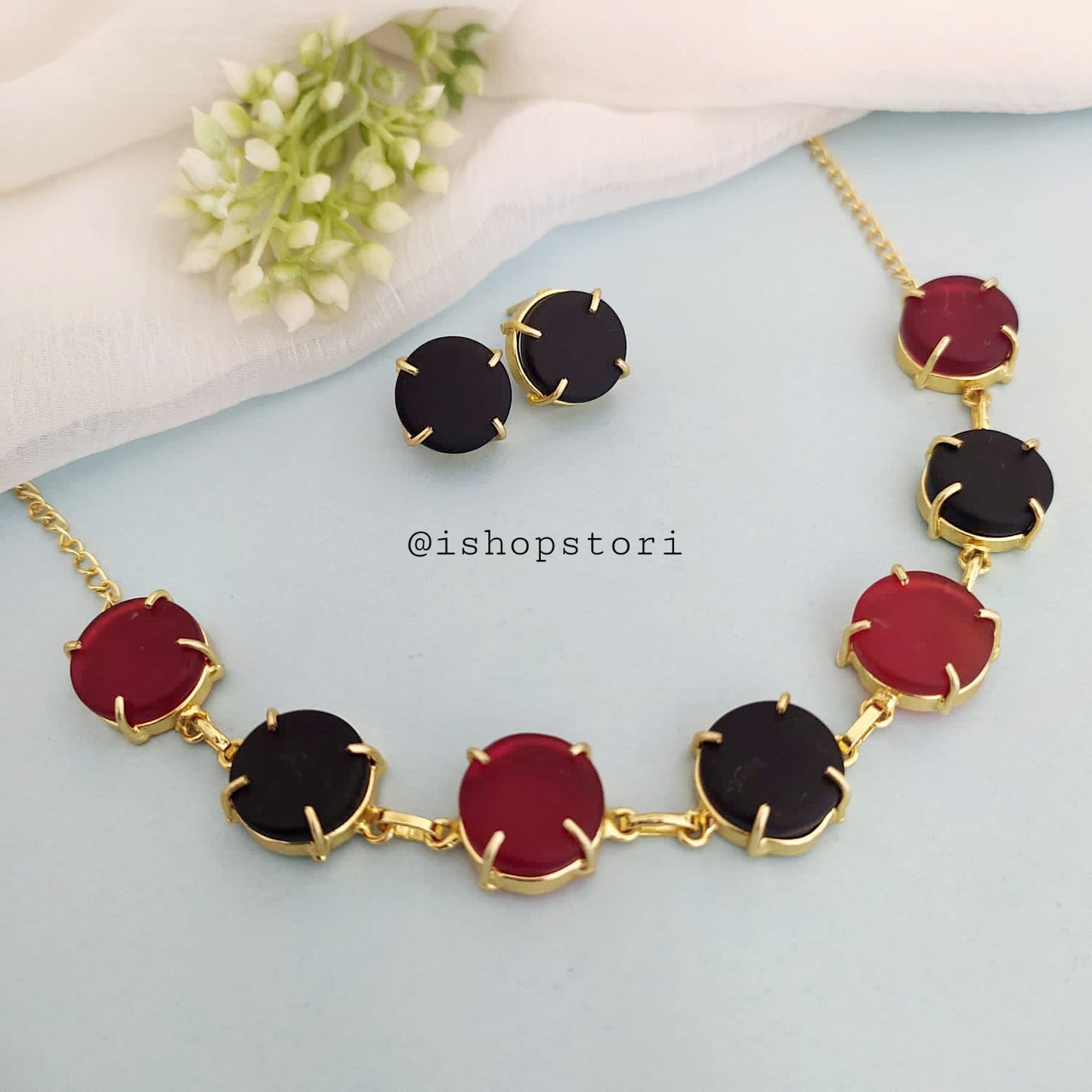 Multi-color raw stone claw necklace in a stylish design with black earrings.
