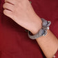 Person wearing a silver bracelet on a red shirt