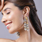 Woman wearing elegant earrings with a neutral background
