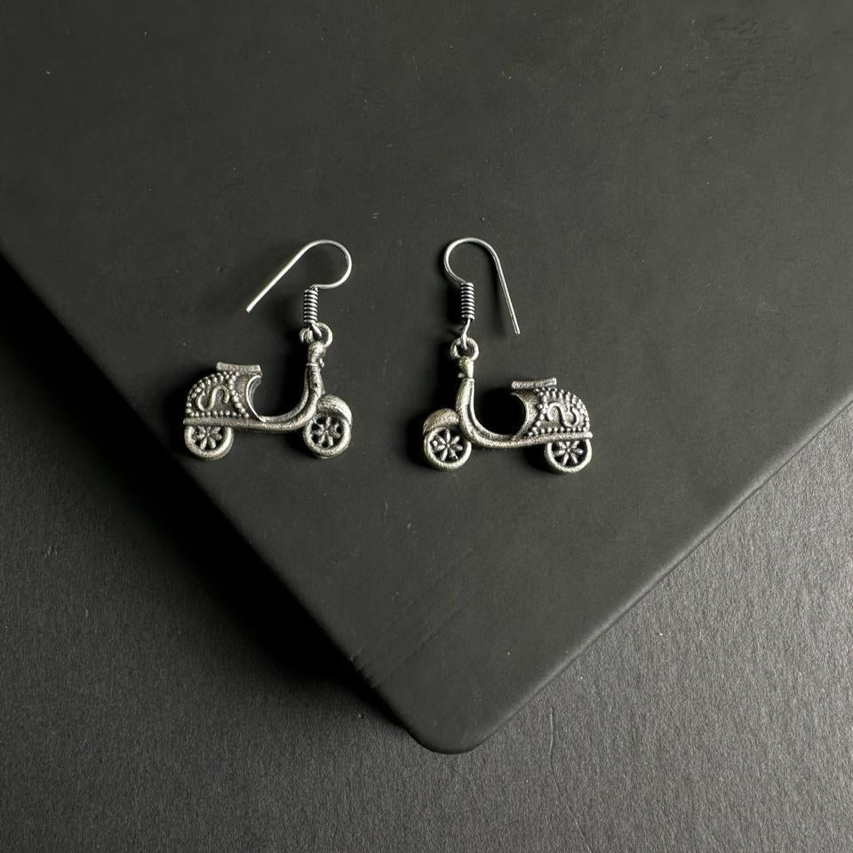 Silver scooter earrings on a dark gray surface