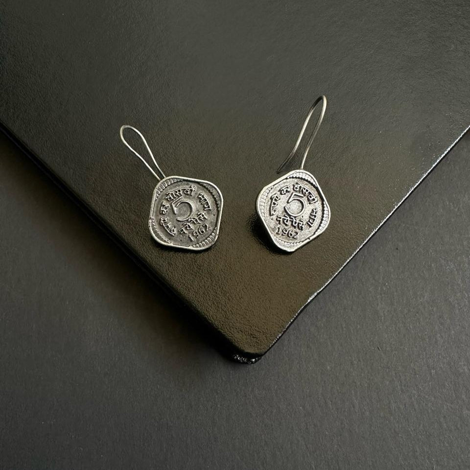Pair of silver earrings on a dark surface