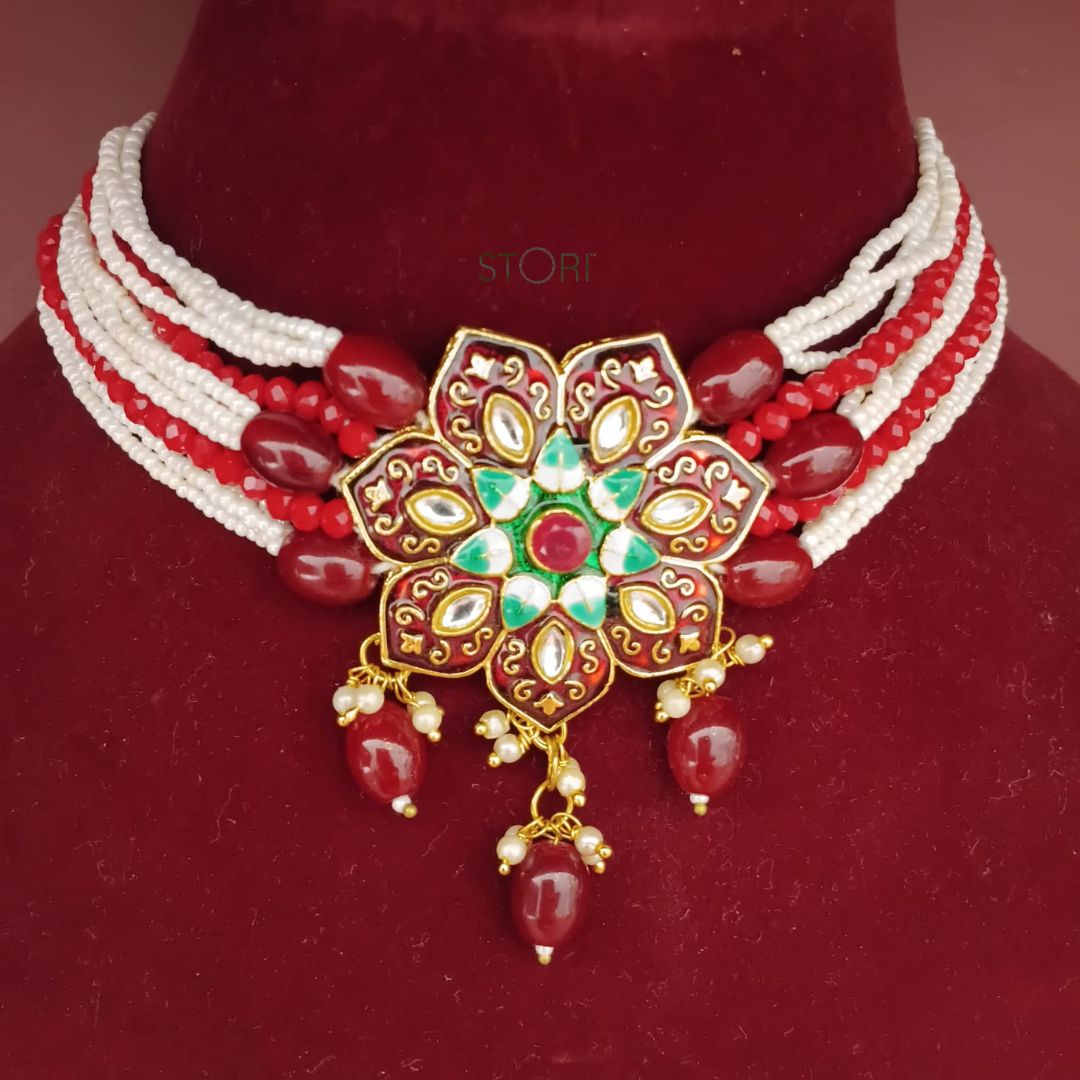 Ornate necklace with red and white beads on a red velvet background