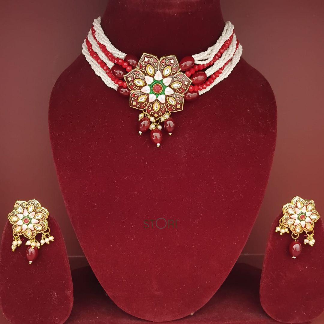 Jewelry set with a necklace and earrings on a red mannequin bust.