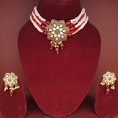 Jewelry set with a necklace and earrings on a red mannequin bust.