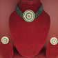 Green beaded necklace and earrings on a red velvet stand with 'TONI' branding.