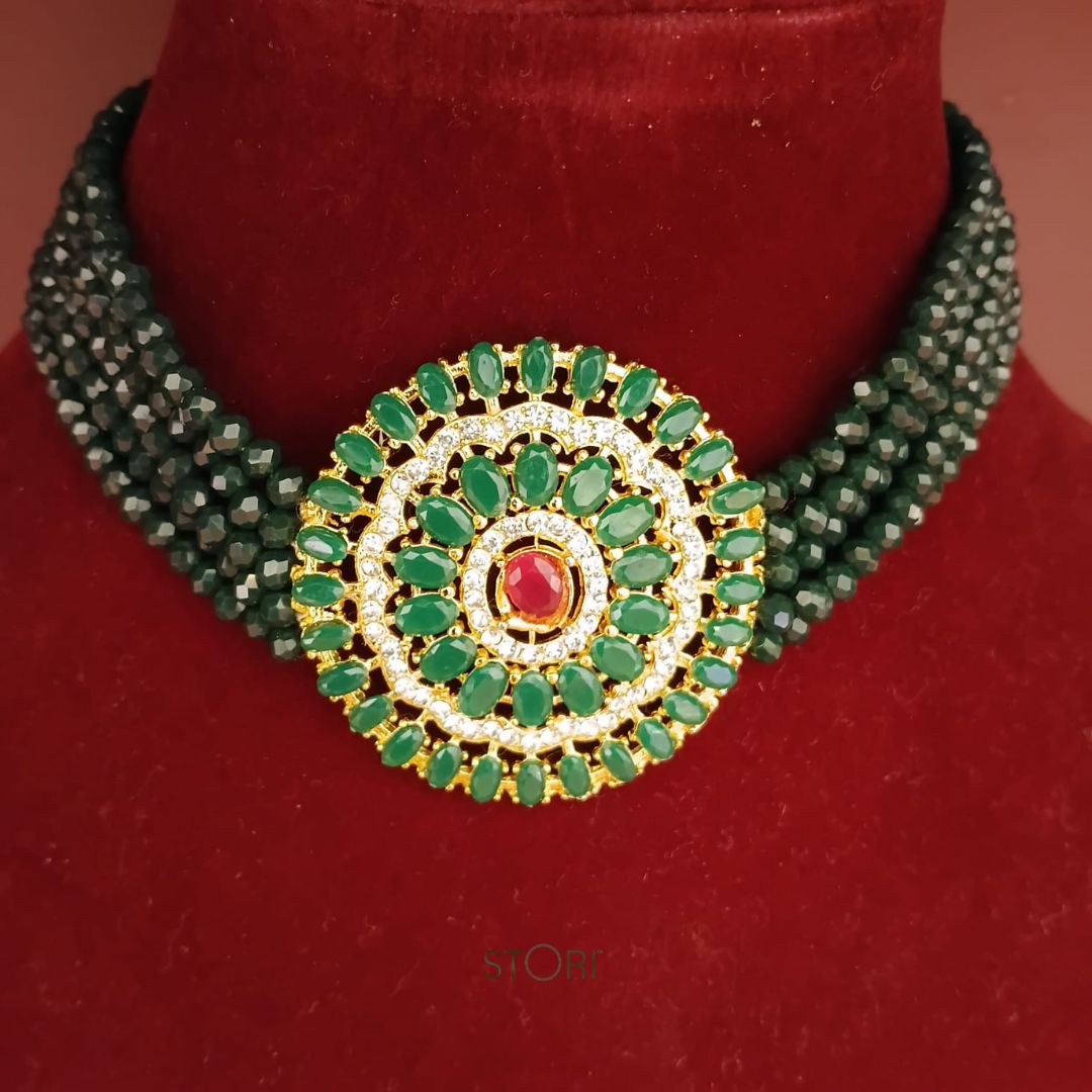 Green beaded necklace with a circular green gemstone pendant on a red background