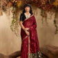 Woman in a maroon saree with a black blouse against a natural backdrop