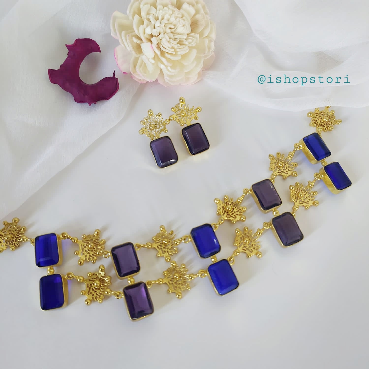Glossy white stone necklace with a double-layer design and dark blue earrings.