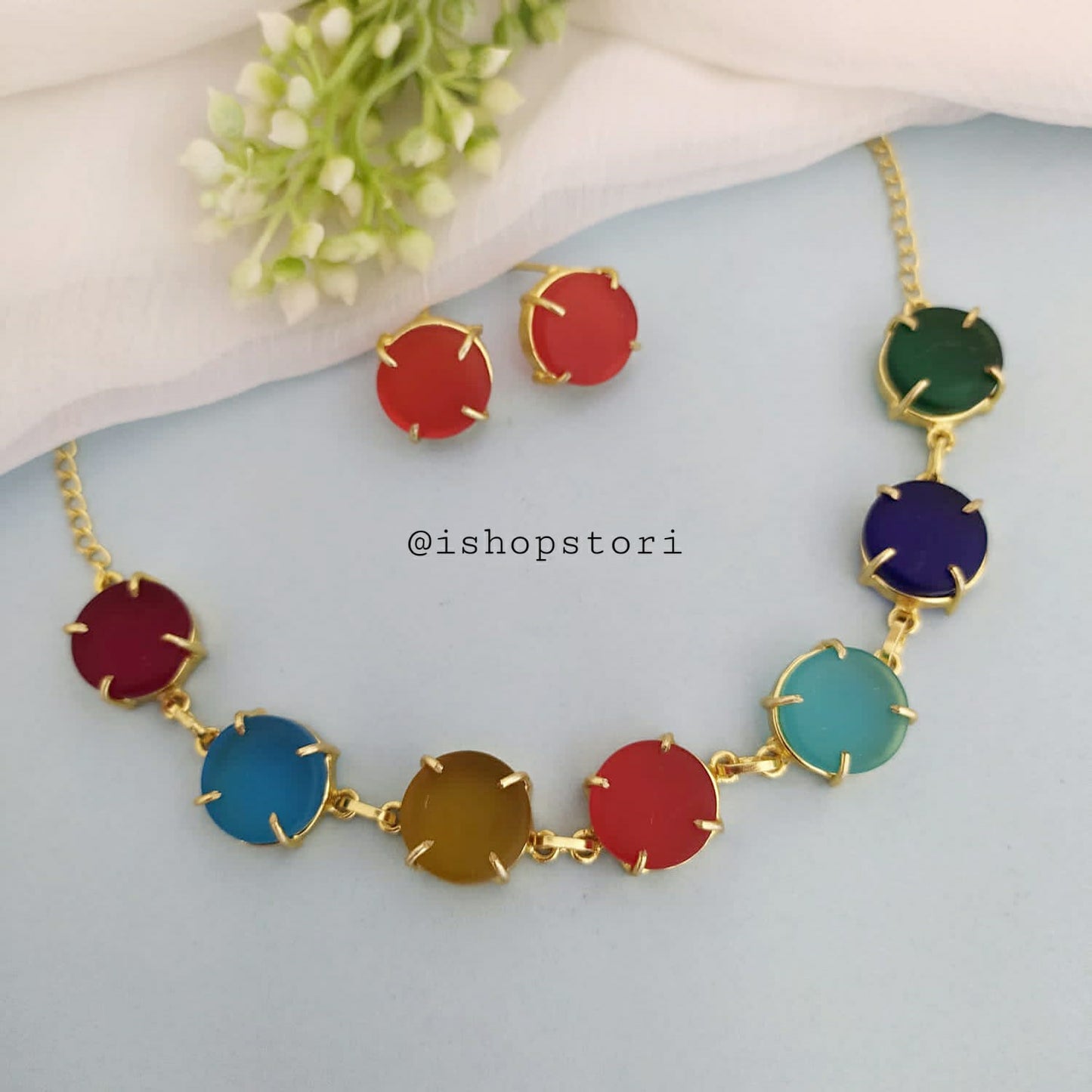 Multi-color raw stone claw necklace in a stylish design with red earrings.
