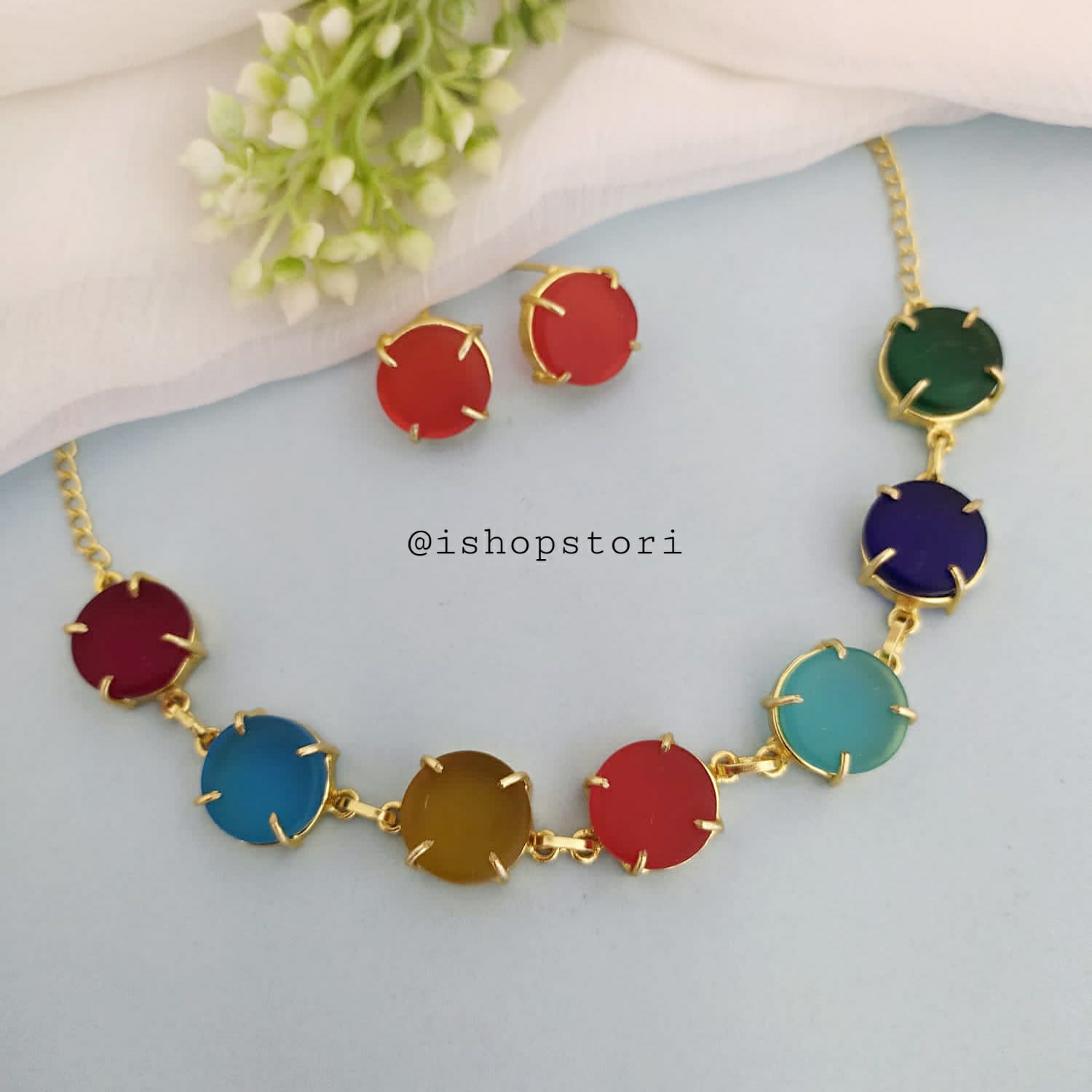 Multi-color raw stone claw necklace in a stylish design with red earrings.