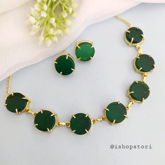 Elegant gold necklace design with single-color raw stones and green earrings. 