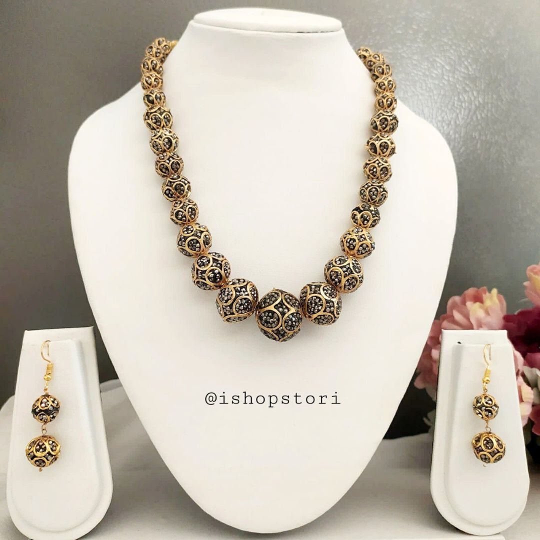 Black and golden pearl choker necklace with matching earrings.