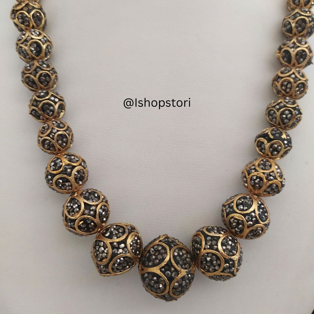 Black and golden pearl choker necklace with matching earrings front view.